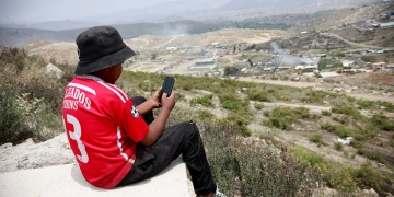 Aldair tiene 12 años y está en primero de secundaria, él espera su turno para usar el celular  de su madre y desarrollar sus clases.