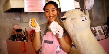 Amy Kang, muestra los pasteles con relleno en forma de alpaca que ofrece en su local.
