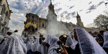 La tradicional primera procesión sólo recorre alrededor de la plaza de Armas. Al fondo, la majestuosa catedral completa el cuadro católico.