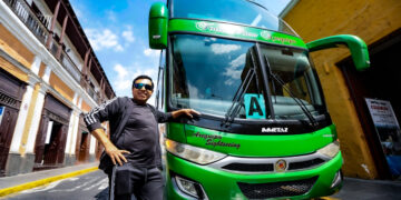 Ángel junto a uno de sus buses turísticos que recorre la ciudad.
