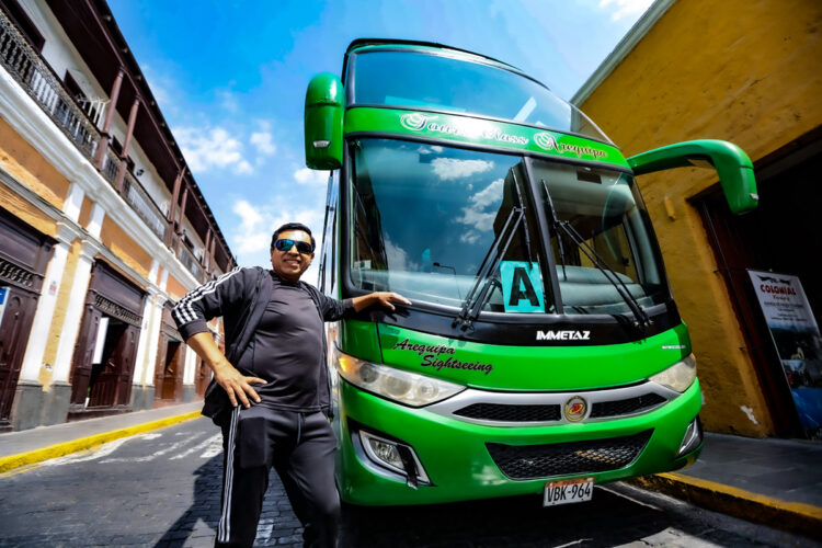 Ángel junto a uno de sus buses turísticos que recorre la ciudad.